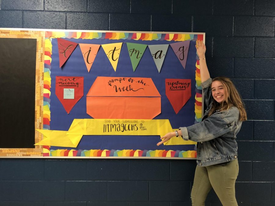 Lit mag member Lucy Roberts poses with the writing prompt board. 