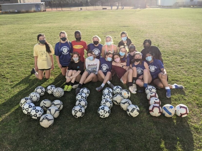 Girls Soccer poses with the word Girl made out of soccer balls