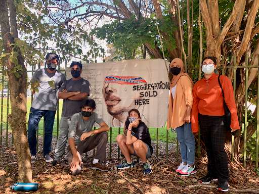 The No Place for Hate club posing with their banner hanging on the gates of Stone Mountain