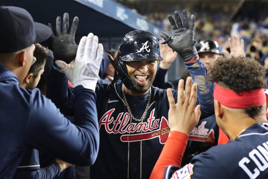 Eddie Rosario high-fives his teammates after hitting a home run in the NLCS