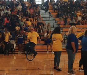 Irvin Wardlow performs on his unicycle at a pep rally