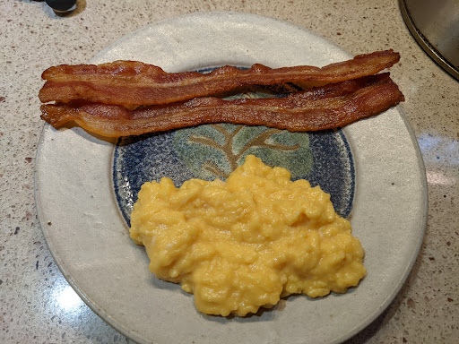 Finished soft scrambled eggs with bacon