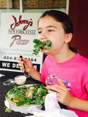 Young staff writer Luiza Douglas chows down on a salad outside the restaurant, Johnnys New York Style Pizza