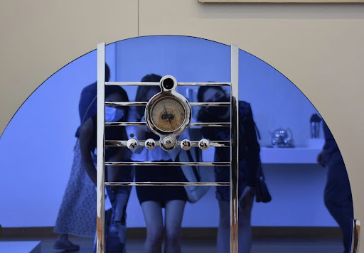 Students pose in front of a blue mirror