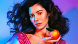 MARINA poses with an orange for an HQ photoshoot in honor of her album "Froot"