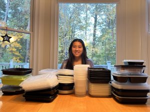 Sophia Wang poses with containers from Retakout’s recent donation drive.
