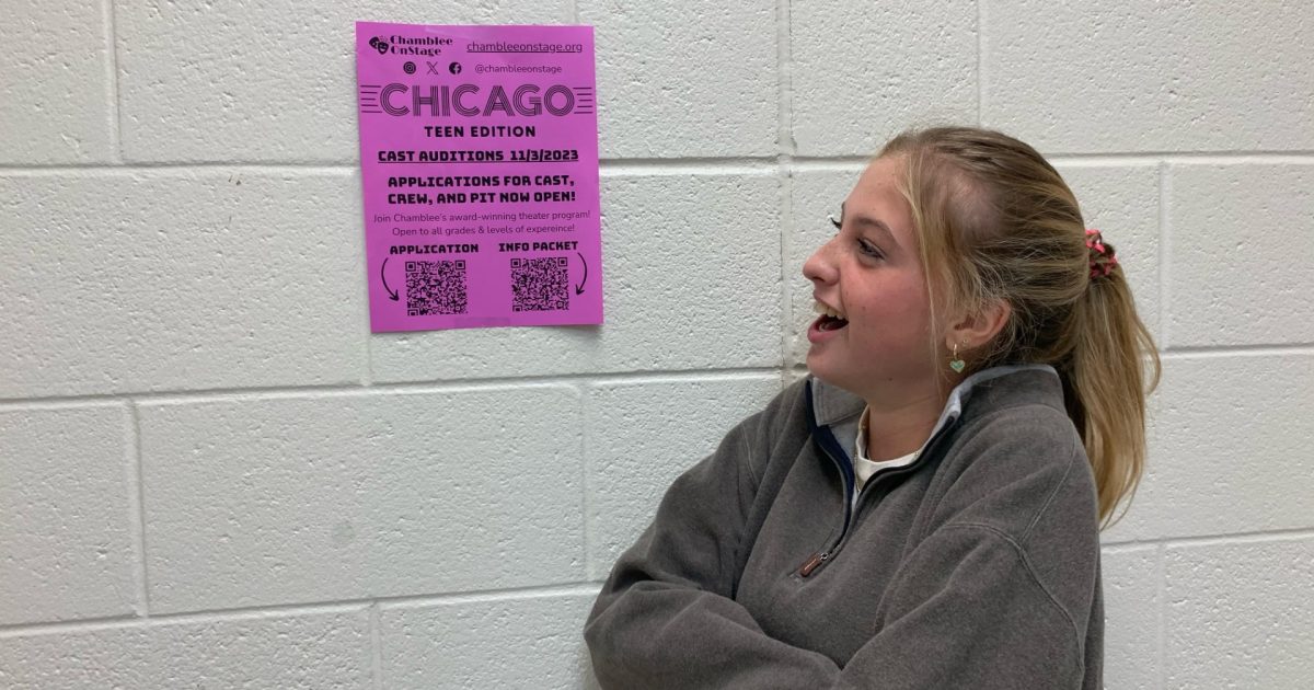 Julia Cashin (26) excitedly posing in front of the audition flyer. Photo Courtesy of Finley Malone