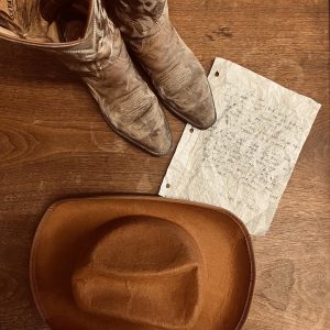 A photo of the lyrics to Chase Rice’s “Hey God It’s Me Again” next to some cowboy stuff. Photo courtesy of Maven Bolick