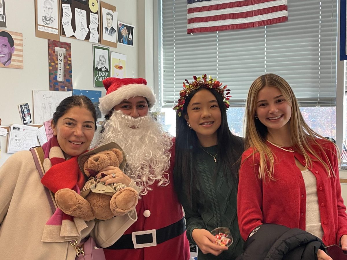 Dr. O, Chelsea Azar ('26), Grace Huang ('27), and Sammy Yarbrough ('26) caroling around the school on St. Nicholas Day. Photo Courtesy of Jennifer Tinnell.