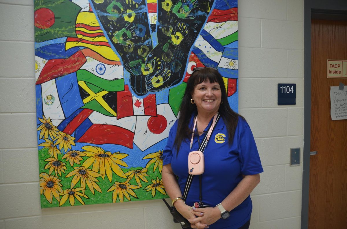 Dr. Conner posing in front of a bulletin board. Photo by Michael Bryant.