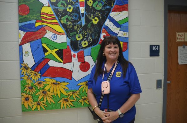 Dr. Conner posing in front of a bulletin board. Photo by Michael Bryant.