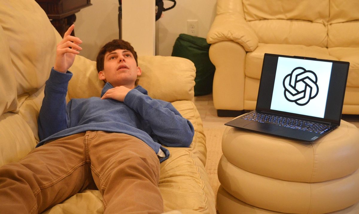 Ben Tocio ('26) posing pretending to talk to ChatGPT like a therapist. Photo by Michael Bryant.