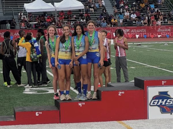(Left to Right) Abigail Mueller ('27), Shae Fagan ('25), Leanna Maender ('26), and Madelyn Herron ('25) celebrating 4th place in the 4x800 relay at State Finals in 2025. 
Photo courtesy of @Chamblee.trackandfield on Instagram.
